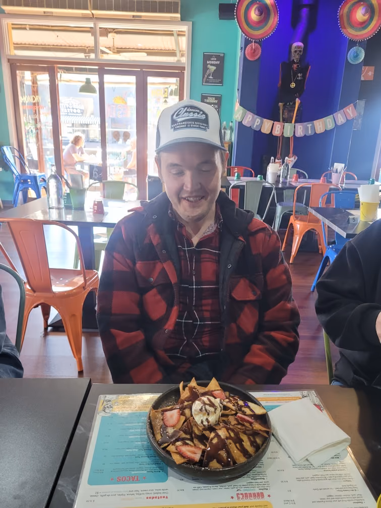 A participant enjoying a birthday dessert at a cafe.