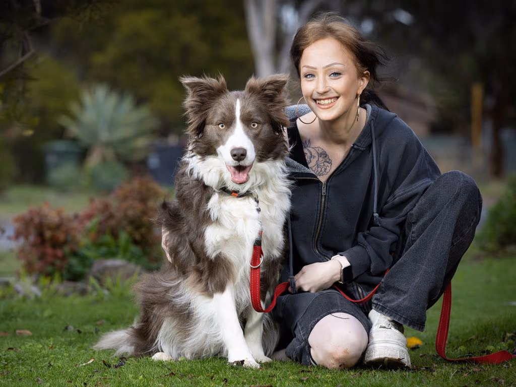 A participant smiling with her dog in the park.