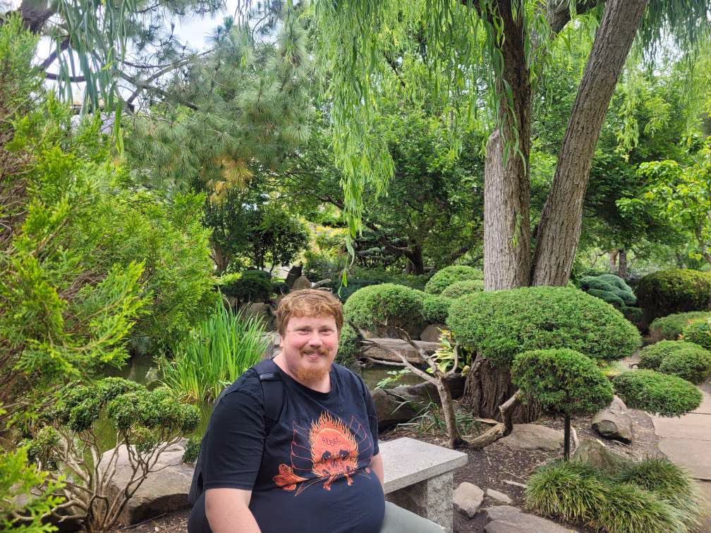 A participant relaxing in a leafy garden.