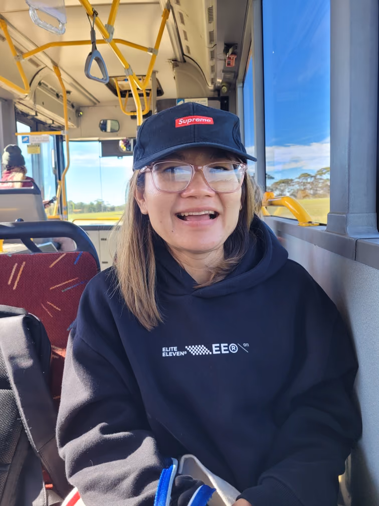 A participant smiling on a group bus outing.