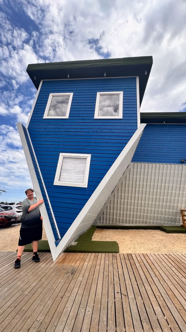 A participant visiting the Upside Down House attraction.