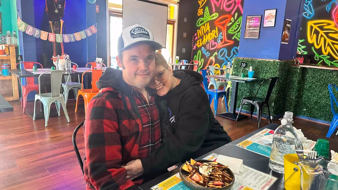 Two participants celebrating together at a colourful restaurant.